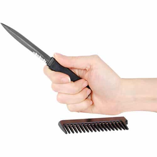 Black comb knife open in hand