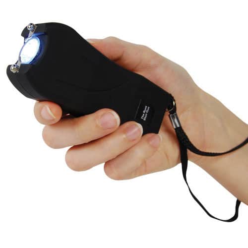 Black runt stun gun in hand with flashlight on