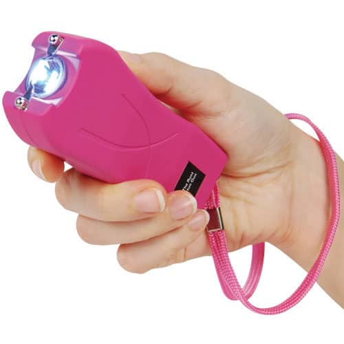 Pink runt stun gun in hand with flashlight on