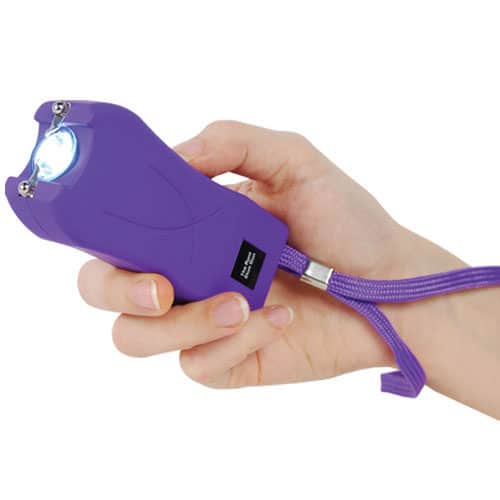 purple runt stun gun in hand with flashlight on